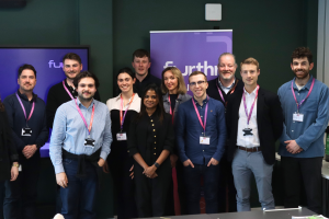 10 start-ups join new Furthr Foundry accelerator. An image of a group of people smiling and standing in front of a sign that says Furthr Foundry.
